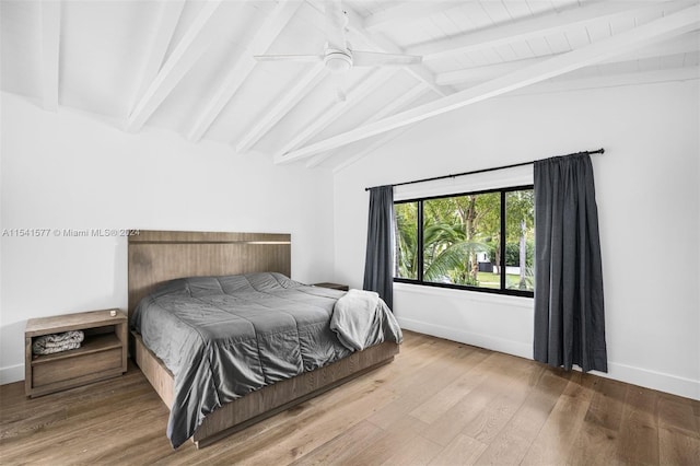 bedroom featuring ceiling fan, light hardwood / wood-style flooring, and lofted ceiling with beams