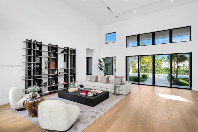 living room featuring a towering ceiling and hardwood / wood-style flooring