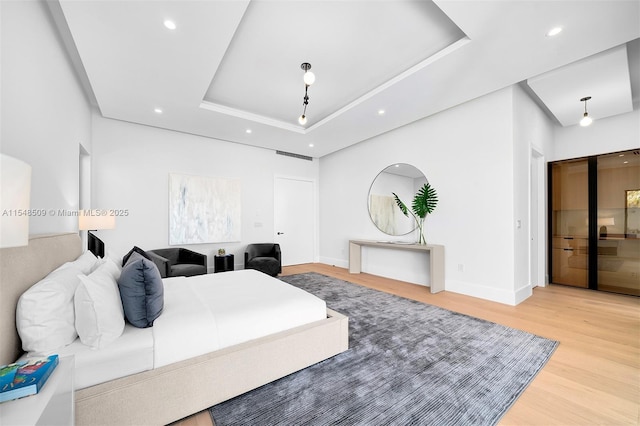 bedroom featuring hardwood / wood-style floors and a tray ceiling