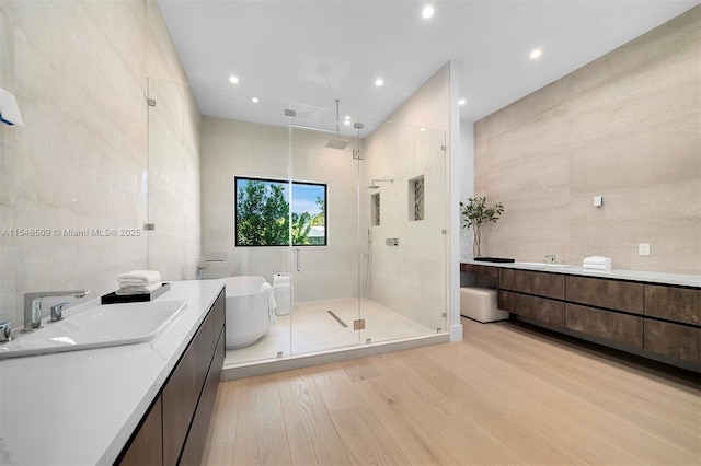 bathroom featuring hardwood / wood-style flooring, vanity, and independent shower and bath