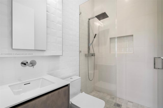 bathroom featuring vanity, toilet, and a shower with shower door