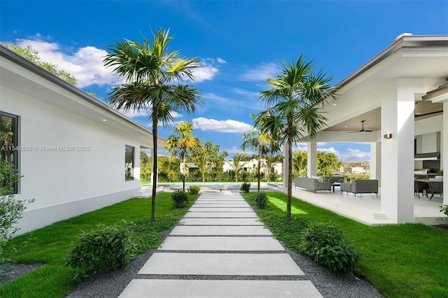 view of yard featuring ceiling fan, a patio area, and an outdoor living space