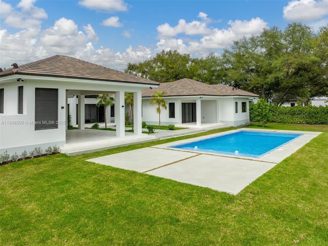 back of property with a lawn and a patio area