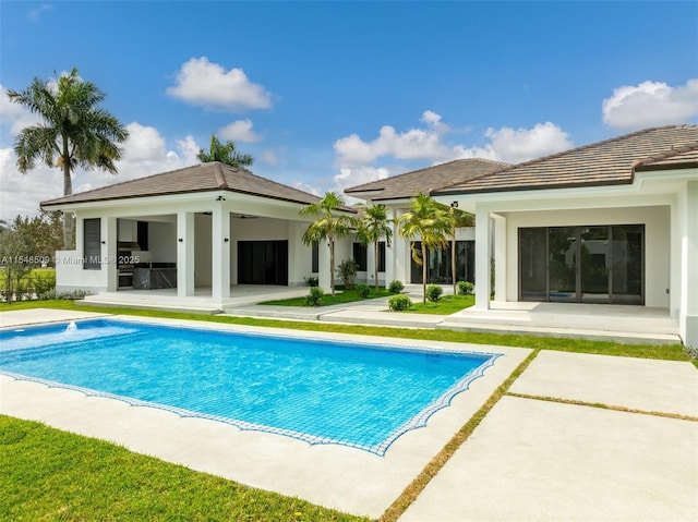 rear view of house featuring area for grilling and a patio area