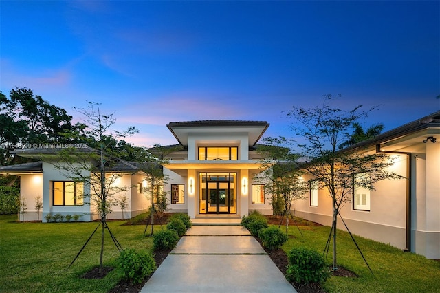 exterior entry at dusk with a yard