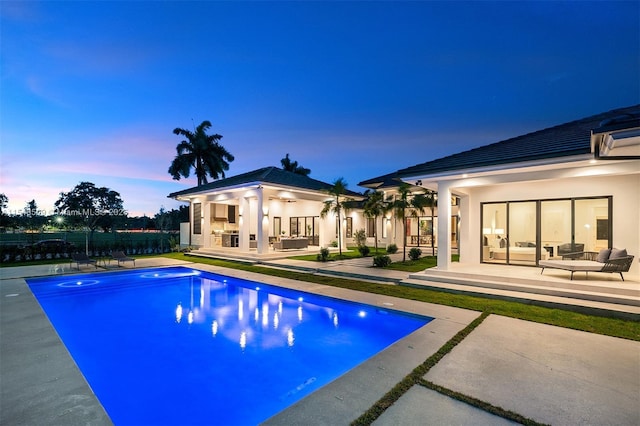 pool at dusk featuring a patio