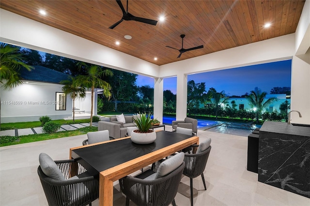 patio terrace at dusk featuring ceiling fan and sink