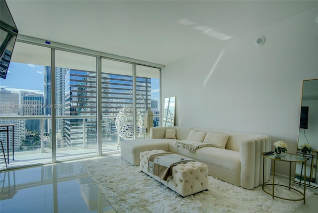 living room featuring baseboards, a wall of windows, and tile patterned floors