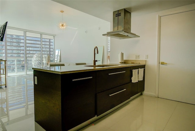 kitchen with decorative light fixtures, light countertops, a sink, island range hood, and a peninsula