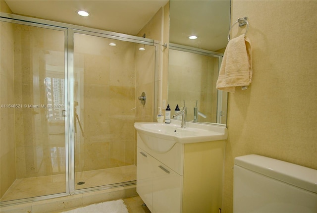 bathroom featuring toilet, a stall shower, recessed lighting, and vanity