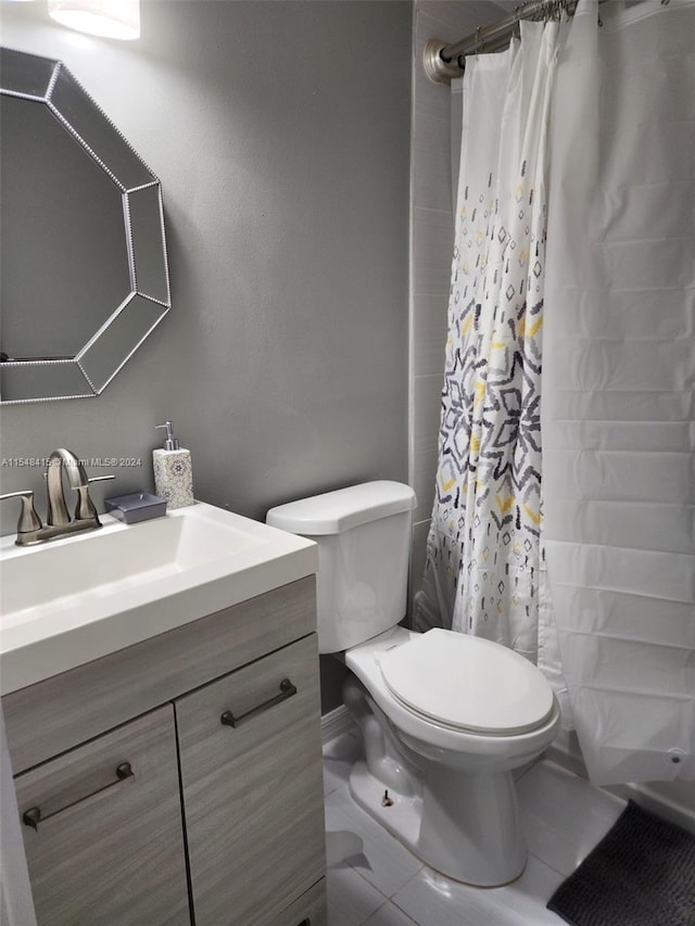 bathroom with tile flooring, toilet, and vanity