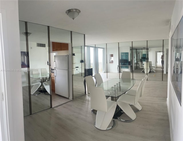 dining space featuring floor to ceiling windows and light hardwood / wood-style flooring