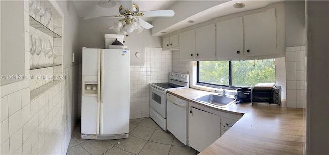 kitchen featuring white appliances, white cabinetry, sink, and tile walls