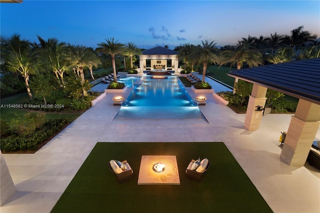 pool at dusk featuring a patio area