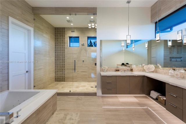 bathroom featuring tile flooring, large vanity, separate shower and tub, and tile walls