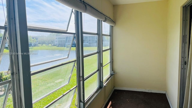 unfurnished sunroom with a healthy amount of sunlight and a water view