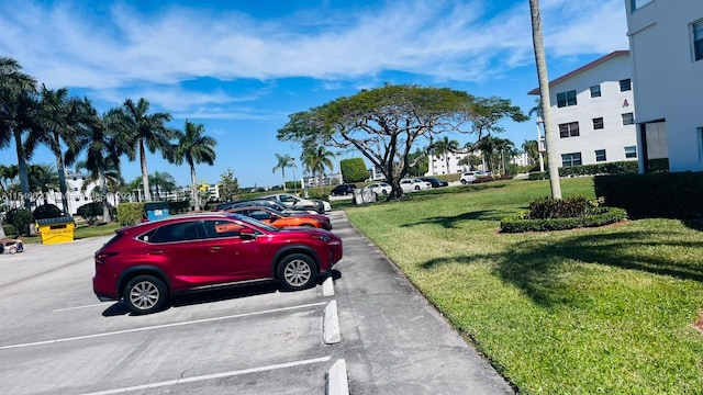 view of parking / parking lot featuring a yard