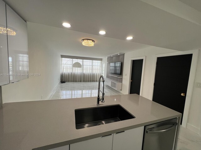 kitchen with dishwasher, white cabinetry, and sink