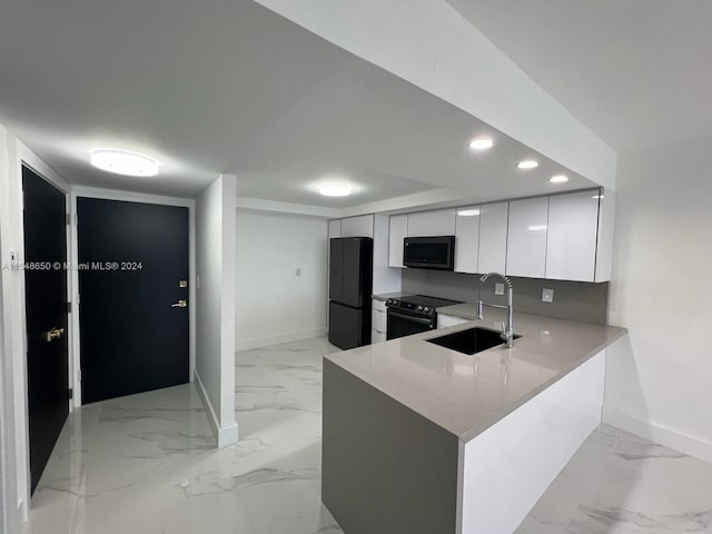 kitchen featuring white cabinets, sink, kitchen peninsula, black appliances, and light stone countertops