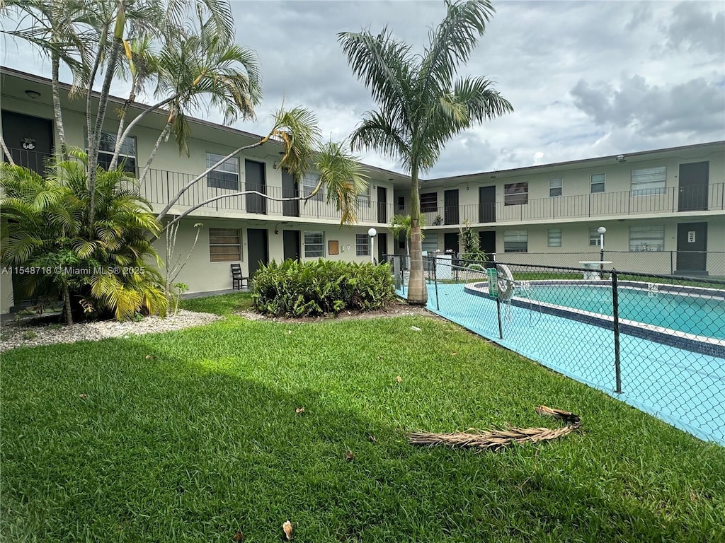 pool with a yard and fence