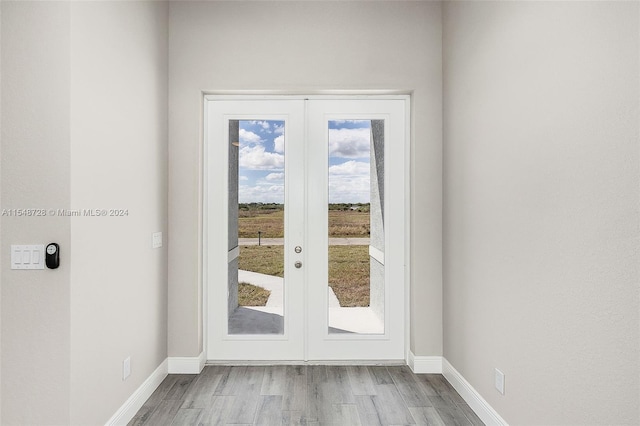 doorway to outside featuring french doors and light wood-type flooring