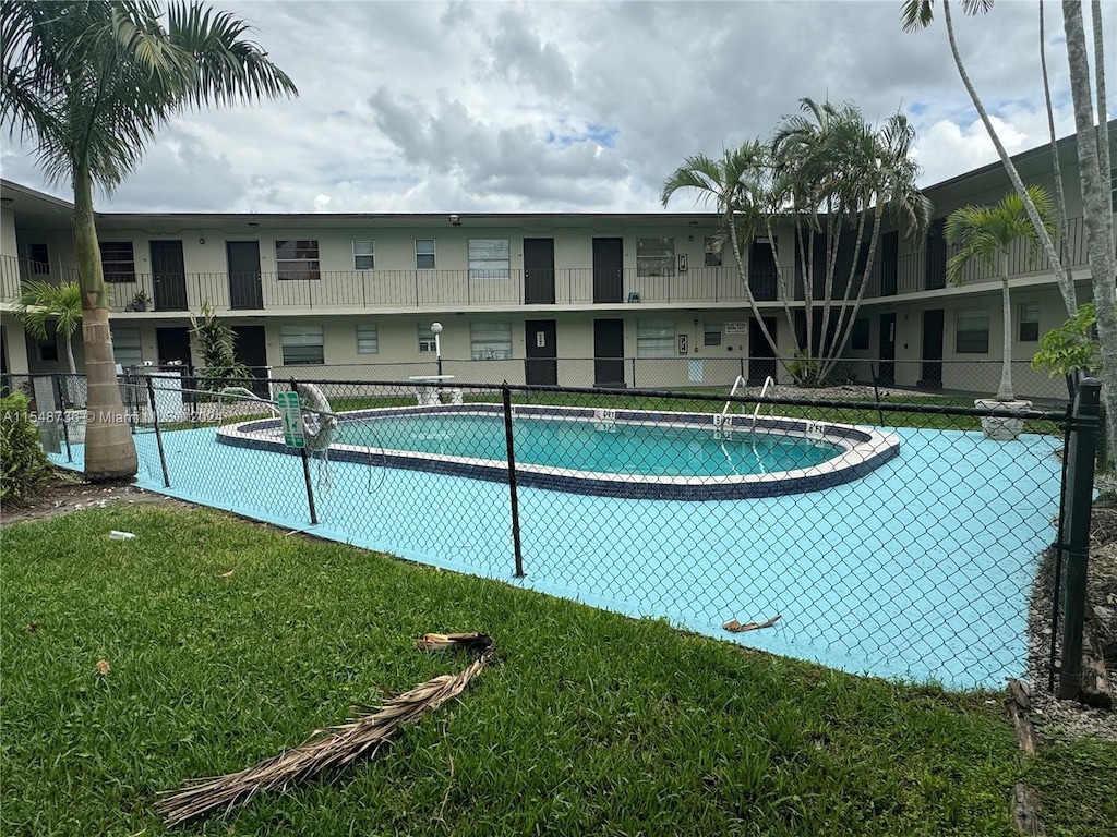 view of swimming pool featuring a lawn