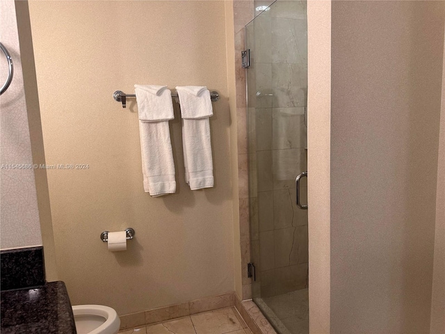 bathroom featuring walk in shower, toilet, and tile floors