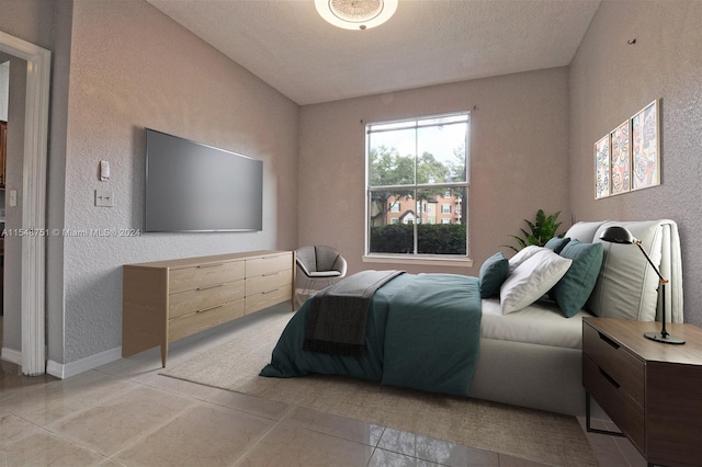 bedroom featuring light tile floors and a textured ceiling