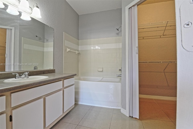 bathroom with tiled shower / bath, tile floors, and vanity with extensive cabinet space