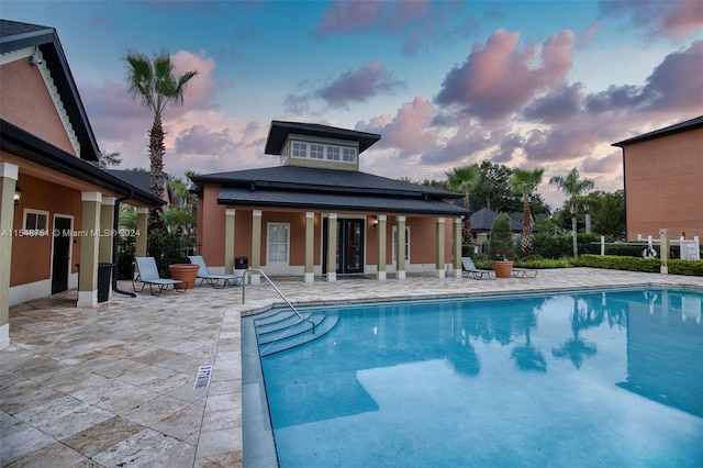 pool at dusk with a patio