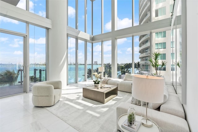 living room featuring a water view and a towering ceiling