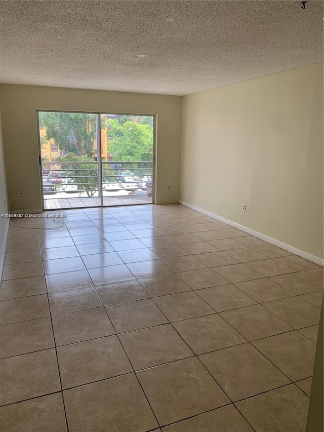 tiled spare room with a healthy amount of sunlight and a textured ceiling