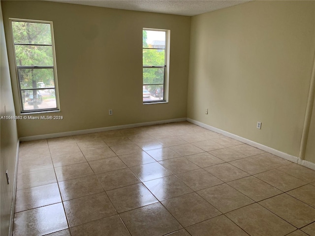 tiled spare room with a textured ceiling