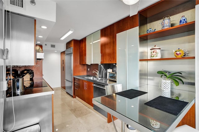 kitchen featuring stainless steel counters, tasteful backsplash, light tile patterned floors, stainless steel appliances, and sink