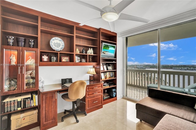 office featuring built in features, ceiling fan, built in desk, and light tile patterned floors