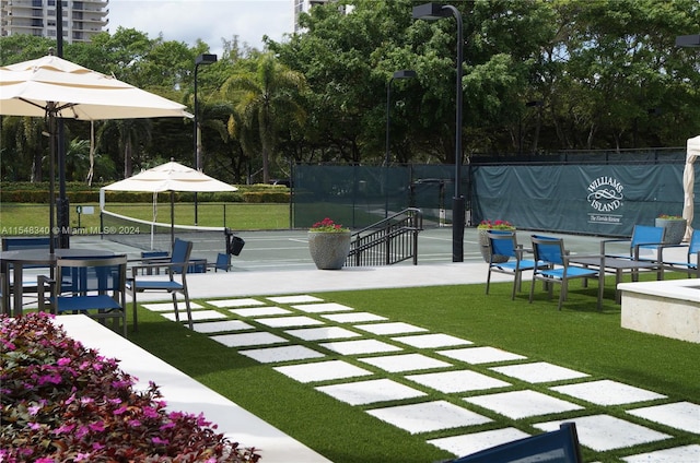 exterior space with tennis court and a yard