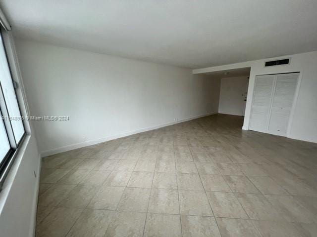 unfurnished bedroom featuring a closet and light tile floors