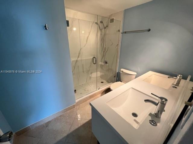 bathroom featuring an enclosed shower, vanity, tile flooring, and toilet