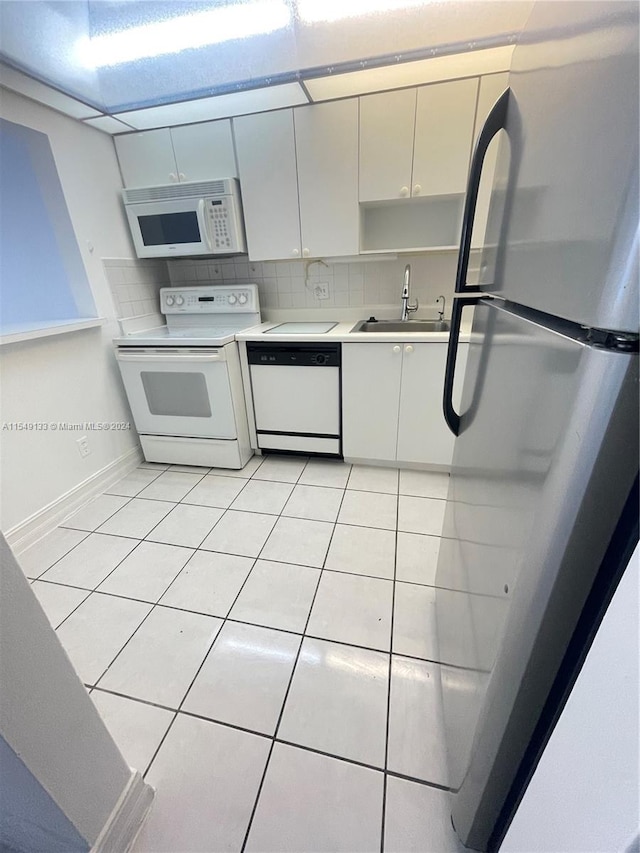 kitchen with light tile flooring, tasteful backsplash, white appliances, and sink