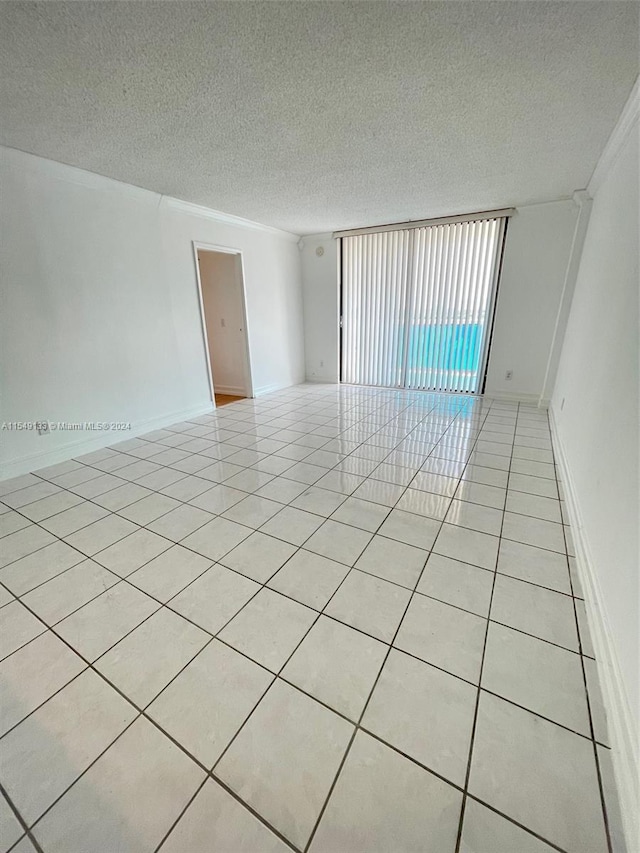 spare room featuring a textured ceiling and light tile floors