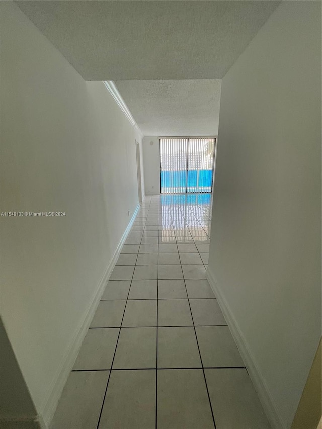 hallway featuring light tile floors and a textured ceiling