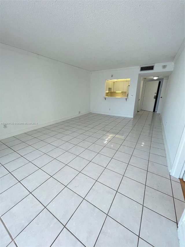 tiled spare room with a textured ceiling