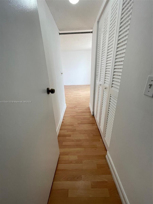 corridor with light hardwood / wood-style floors