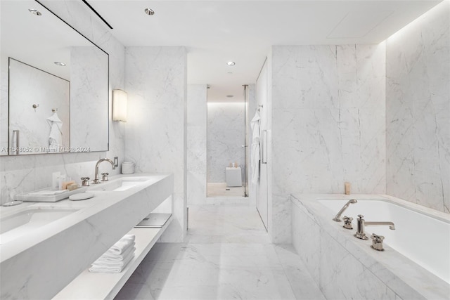 bathroom with plus walk in shower, tile flooring, dual bowl vanity, and tile walls