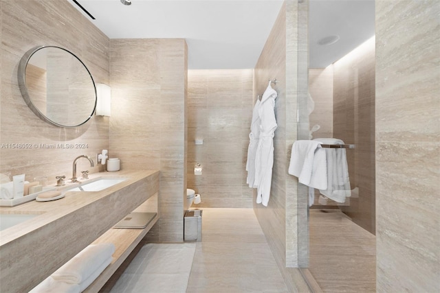 bathroom featuring vanity, tile floors, toilet, and tile walls