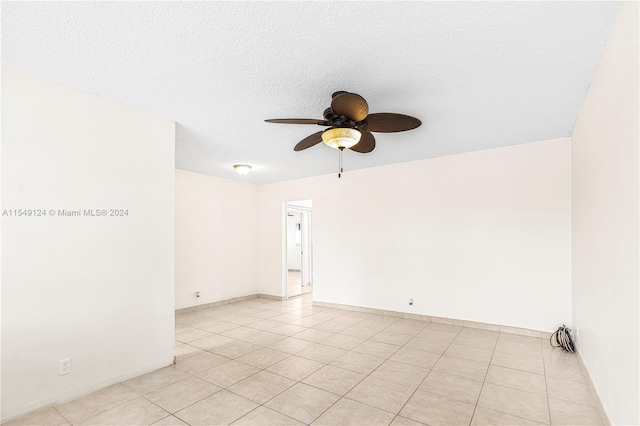 tiled spare room with a textured ceiling and ceiling fan