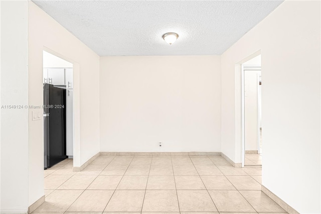 spare room with light tile floors and a textured ceiling