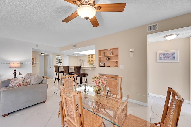 dining space with built in features, light tile floors, and a textured ceiling