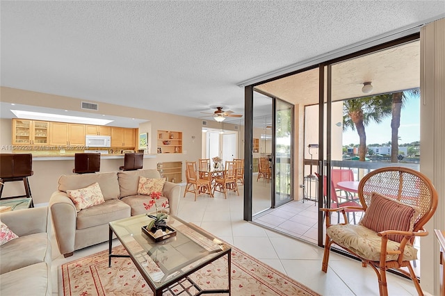 tiled living room with floor to ceiling windows, a textured ceiling, and ceiling fan