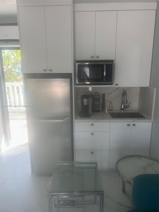 kitchen featuring white cabinets, light tile flooring, sink, and stainless steel appliances